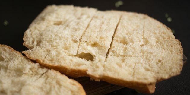 Como fazer croutons de queijo e alho: dividir um pão pela metade