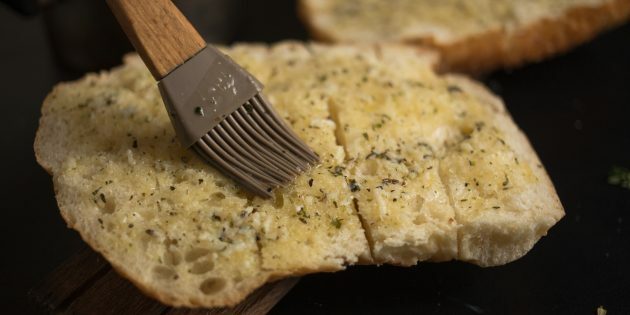 Como fazer croutons de queijo com alho: espalhe manteiga por toda a superfície do pão