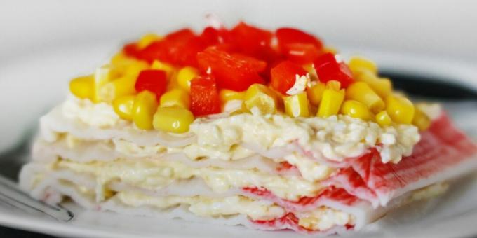 Salada em camadas de palitos de caranguejo com queijo e ovo