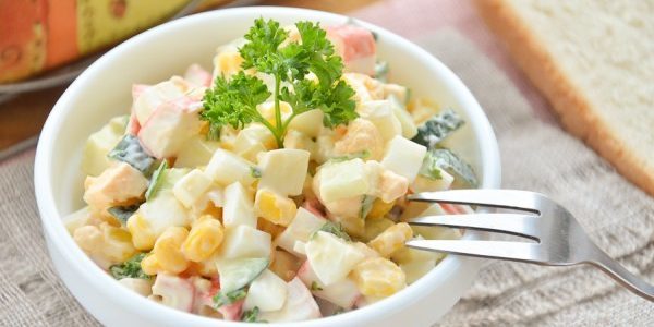 Salada com varas do caranguejo, milho e ovos