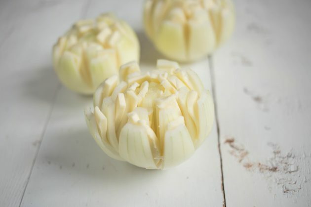 Coloque uma fatia fina de queijo entre as fileiras de pétalas de flores de cebola