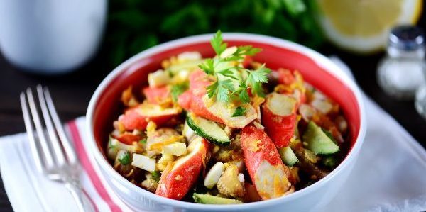 Salada com fritos de caranguejo varas, cogumelos, pepino e ovos